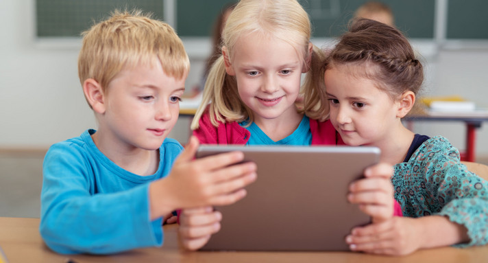 Kinder benutzen ein Tablet im Unterricht
