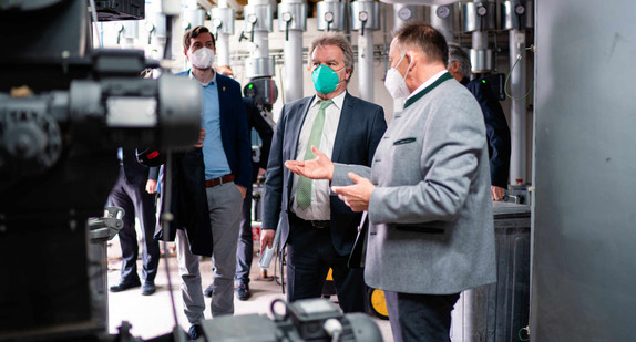 Hubert Flaig (3. von links) erläutert Minister Franz Untersteller (Mitte) bei einem Rundgang durch die Schreinerei das Nahwärme-Verbundsystem, das gemeinsam mit Brugger Magnetsysteme GmbH umgesetzt wurde.