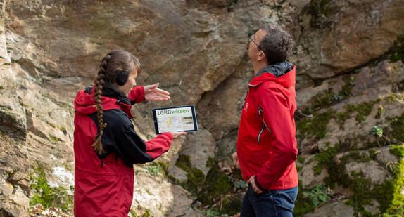 Frau erklärt anhand eines Tabletts die neue Internetplattform LGRBwissen