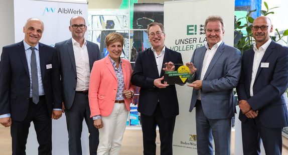 Umwelt- und Energieminister Franz Untersteller (5. von links) zeichnet das Alb-Elektrizitätswerk in Geislingen als „Ort voller Energie“ aus und überreicht dem Vorstandsvorsitzenden Hubert Rinklin die Plakette. Mit dabei (von links): Vorstandsmitglied Gerhard Ueding, Oberbürgermeister Frank Dehmer, Landtagsabgeordnete Nicole Razavi und Vorstandsmitglied Bernd Rößner.