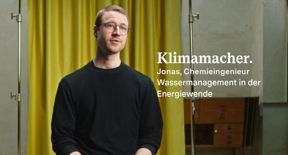 Jonas Ullmann schaut in die Kamera, im Hintergrund ist ein Vorhang zu sehen.