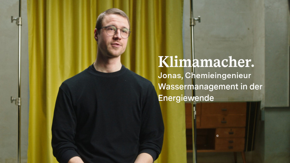 Jonas Ullmann schaut in die Kamera, im Hintergrund ist ein Vorhang zu sehen.
