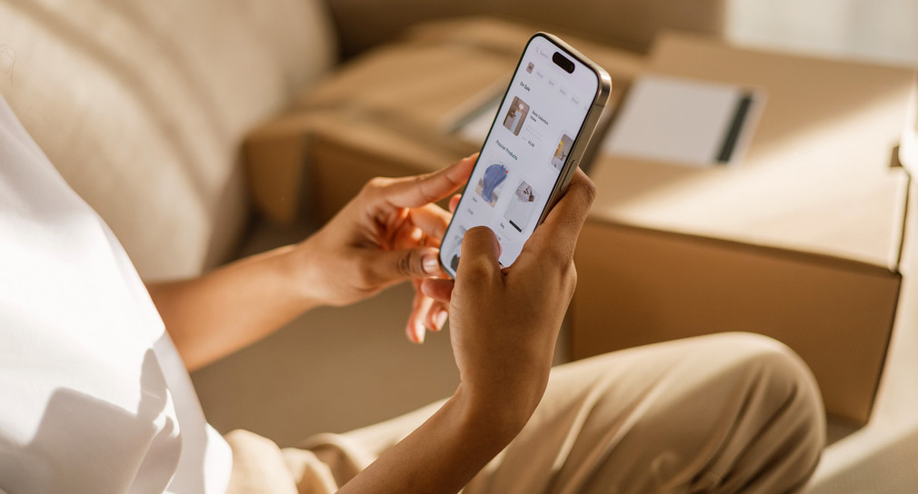 Eine Frau kauft zu Hause online per Handy ein