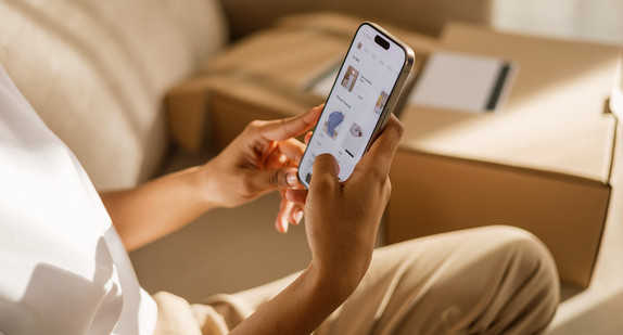 Eine Frau kauft zu Hause online per Handy ein