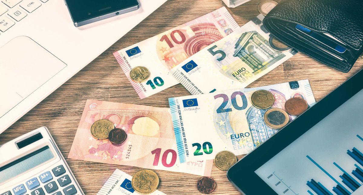 Euromünzen, Geldscheine und Diagramm auf einem Tablet