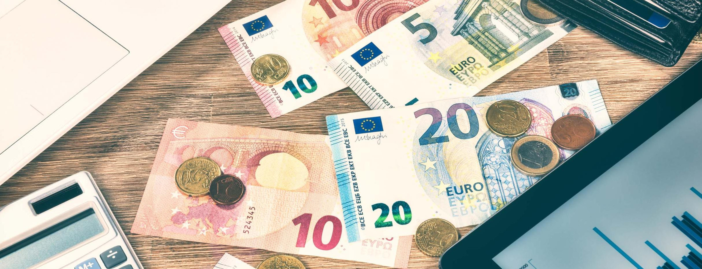 Euromünzen, Geldscheine und Diagramm auf einem Tablet