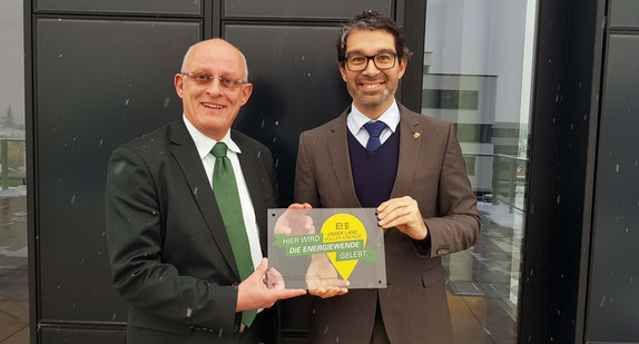 Das Zentrum für Sonnenenergie- und Wasserstoff-Forschung (ZSW) wurde als ein „Ort voller Energie“ ausgezeichnet. Umweltstaatssekretär Andre Baumann (rechts) überreicht dem geschäftsführenden ZSW-Vorstand Prof. Frithjof Staiß die Wandtafel.