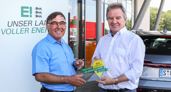 Umwelt- und Energieminister Franz Untersteller (2. von links) zeichnet das Autohaus Bach-Hegau in Singen als „Ort voller Energie“ aus und überreicht Geschäftsführer Klaus Bach die Plakette.