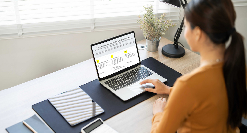 junge Frau sitzt vor einem Laptop und arbeitet mit dem KompVZ