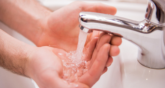 Person wäscht Hände unter fließendem Wasser