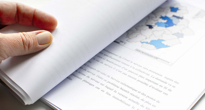 Person blättert in einem Bericht