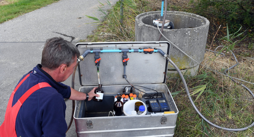 Ein Mann nimmt für die Landesanstalt für Umwelt, Messungen und Naturschutz Baden-Württemberg (LUBW) an einer Messstelle eine Grundwasserprobe, die in einem Labor auf Nitrat überprüft wird.