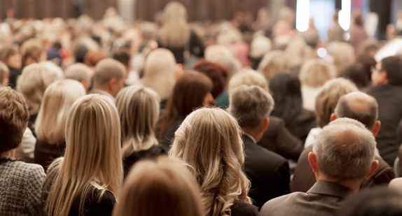 Menschen in einem Saal von hinten