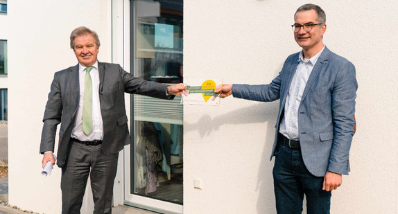 Privates Wohnhaus in Ochsenhausen ist ein „Ort voller Energie“. Minister Franz Untersteller (links) übergibt Bauherrn Wolfgang Schafitel die Plakette mit der Inschrift "Hier wird die Energiewende gelebt".