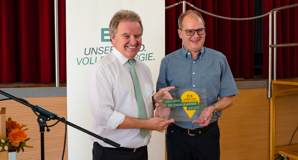 Umweltminister Franz Untersteller (links) überreicht Bürgermeister Amin Reitze die Auszeichnung „Hier wird die Energiewende gelebt“.