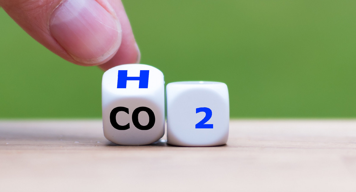 Zwei Finger drehen einen Würfel und ändern CO2 zu H2