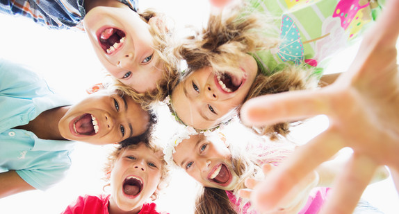 Kinder blicken in eine Kamera herunter