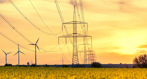 Strommasten und Windr&auml;der im Sonnenuntergang