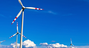 Windräder vor blauem Himmel mit Wolken